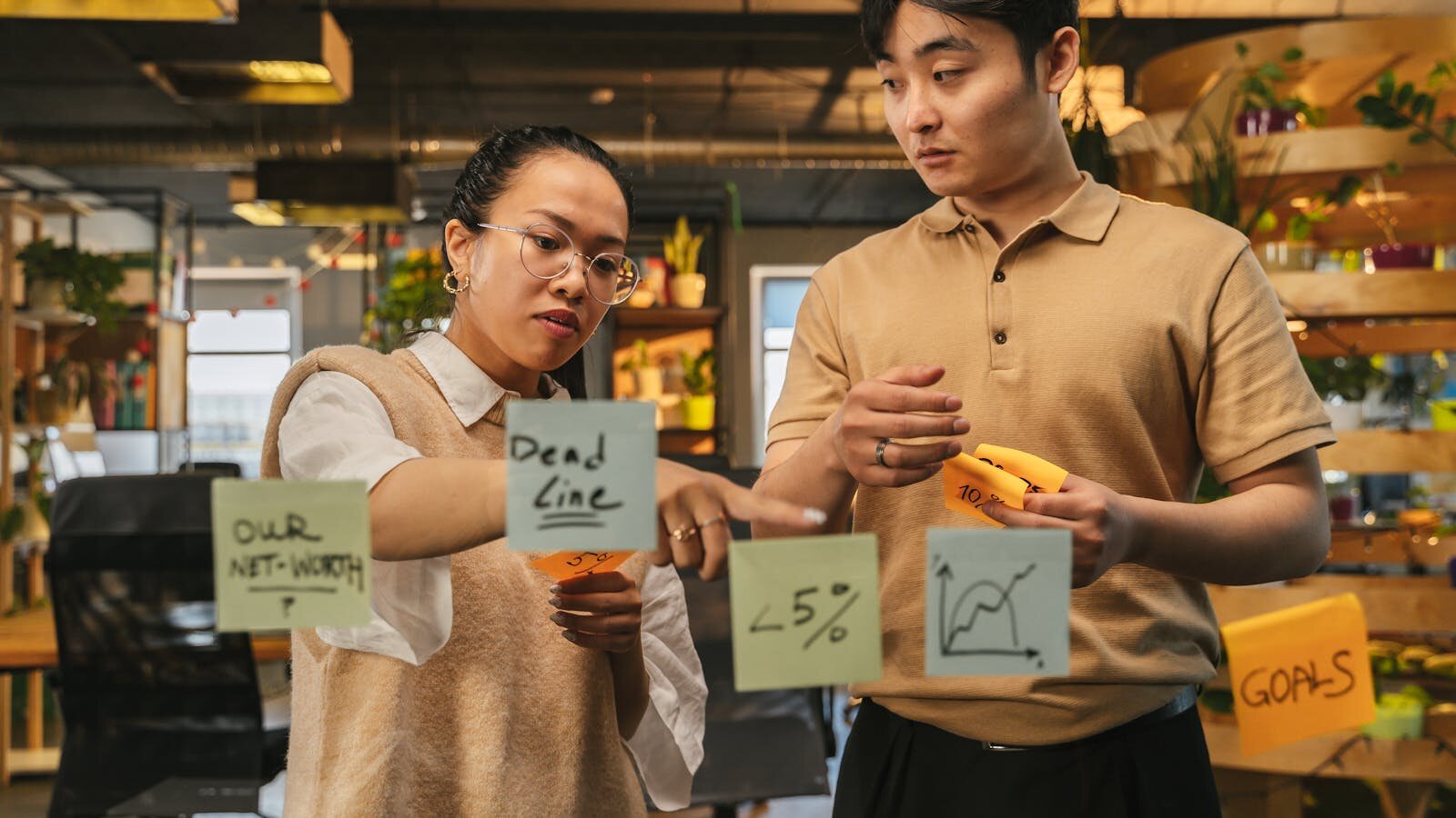 A professional writing on a glass board during a collaborative review session
