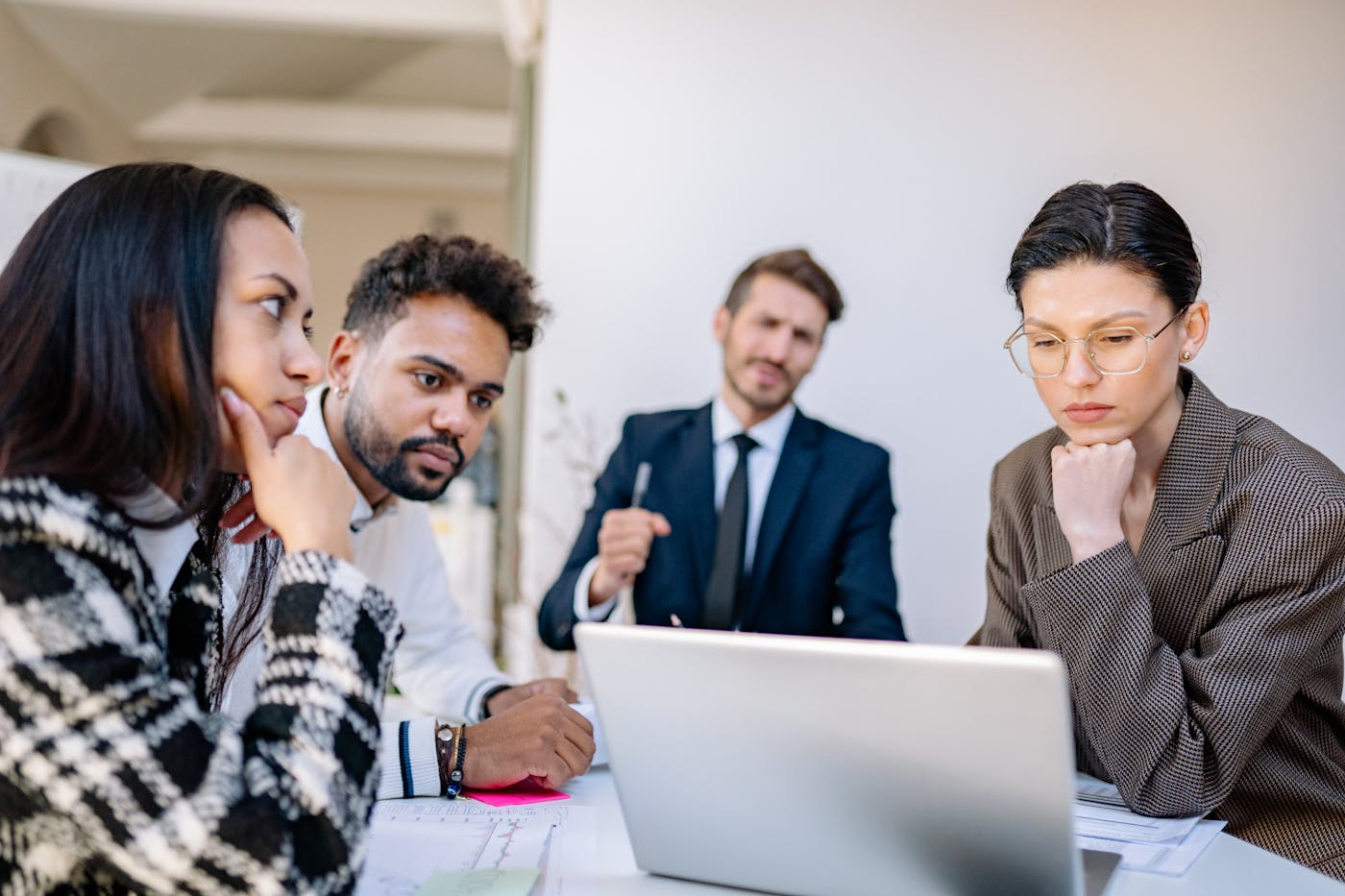 A business team planning a digital product together around a laptop and printed notes